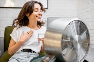 Frau vor dem Ventilator für eine Abkühlung, femme devant le ventilateur pour se rafraîchir
