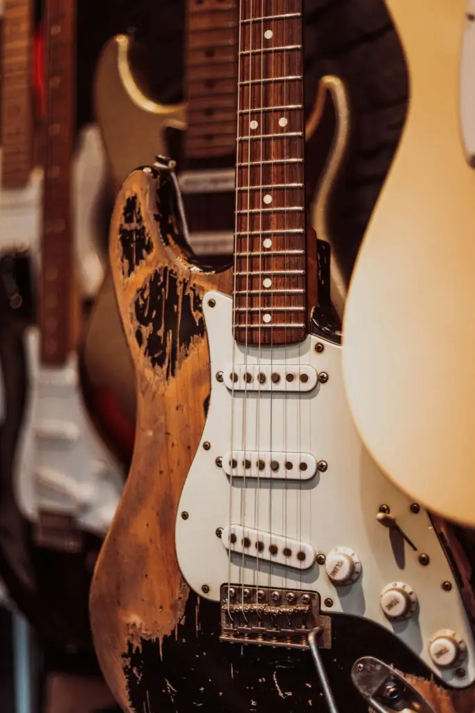 Die optimale Luftfeuchtigkeit für Gitarren: So bleiben Klang und Holz dauerhaft stabil 1 Gitarre abgenutzt hängt an der wand. Luftfeuchtigkeit für gitarren